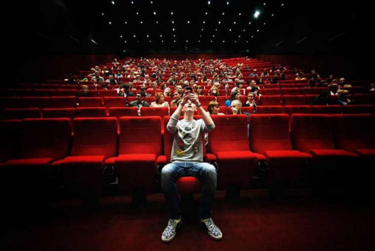 Человек в кинотеатре с попкорном