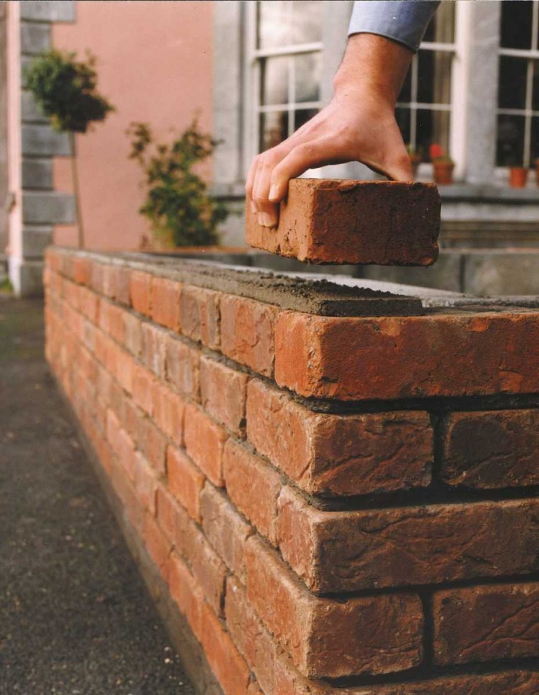 Кладет кирпич