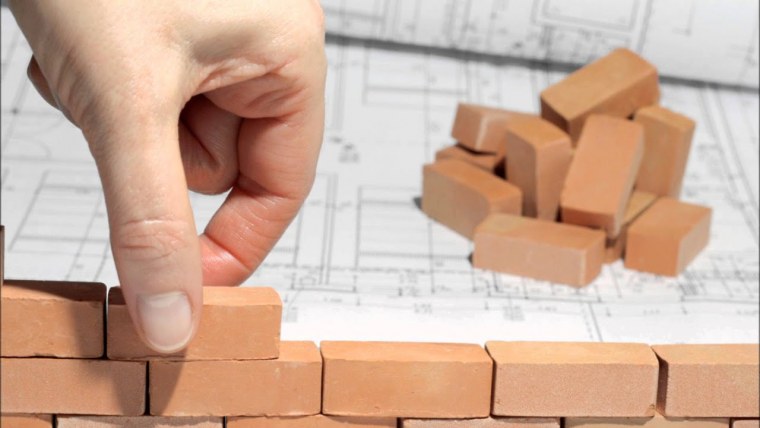 Рука кладет кирпич