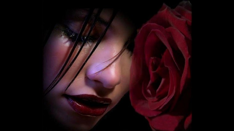 Рука с розой на черном фоне