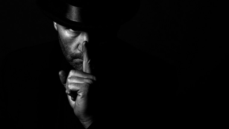 Мужчина в шляпе на черном фоне