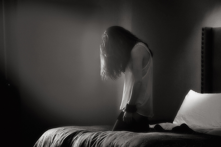 Девушка сидит на коленях на кровати