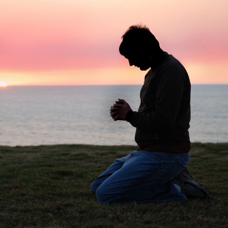 Мужчина молится на коленях