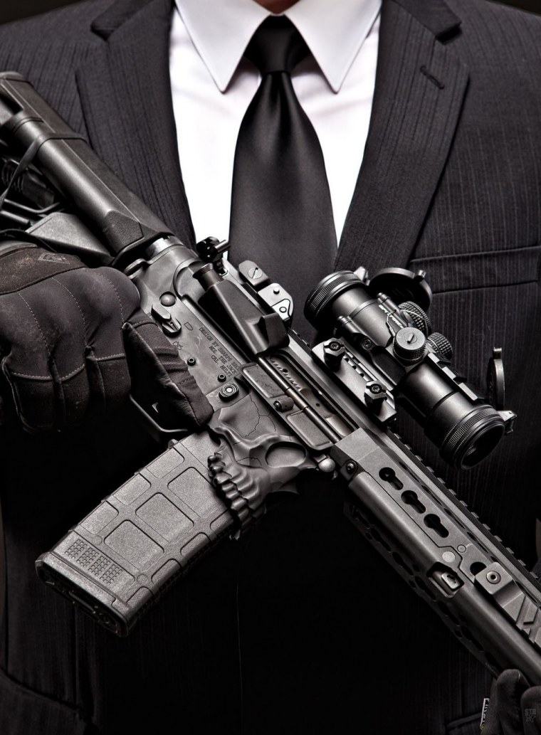 Мужчина в костюме с пистолетом