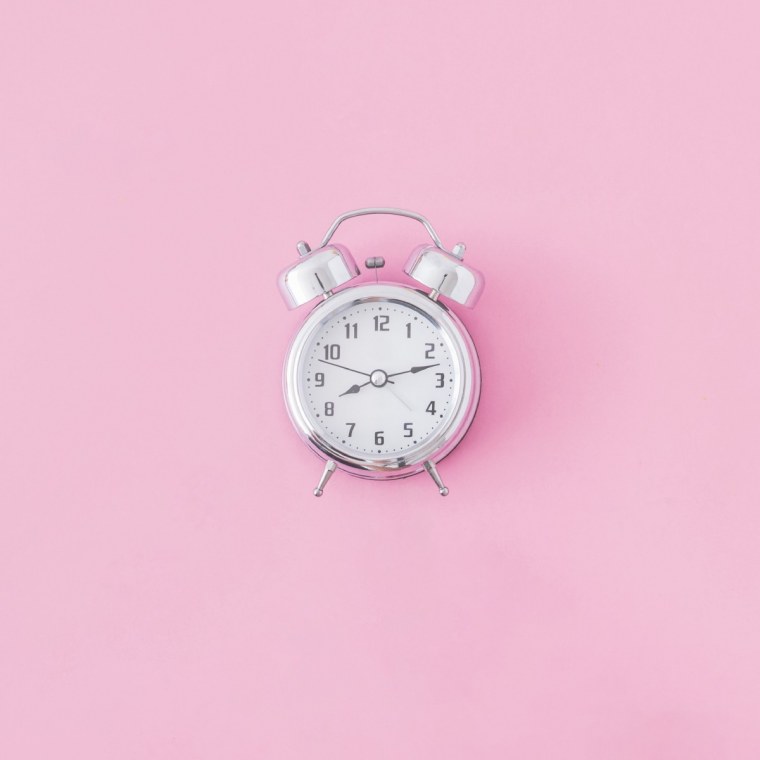 Будильник на розовом фоне