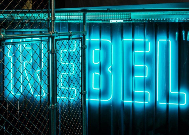 Неоновый логотип на стене