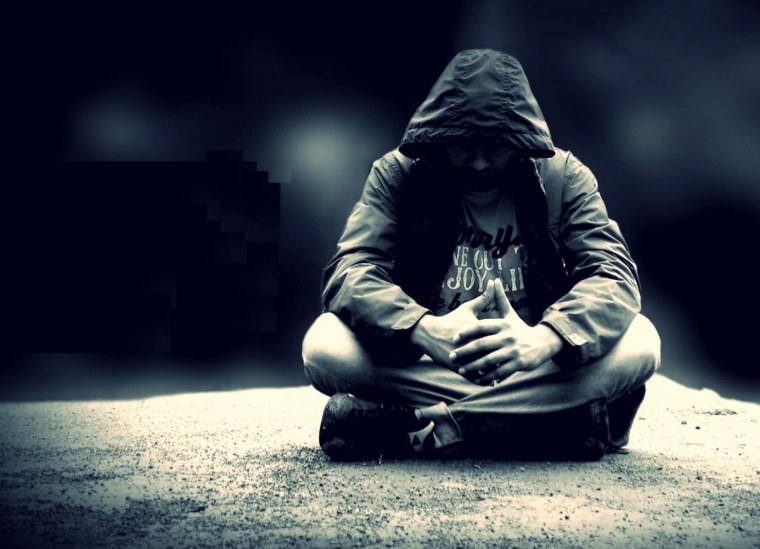 Парень в капюшоне сидит