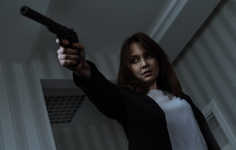 Испуганная девушка с пистолетом